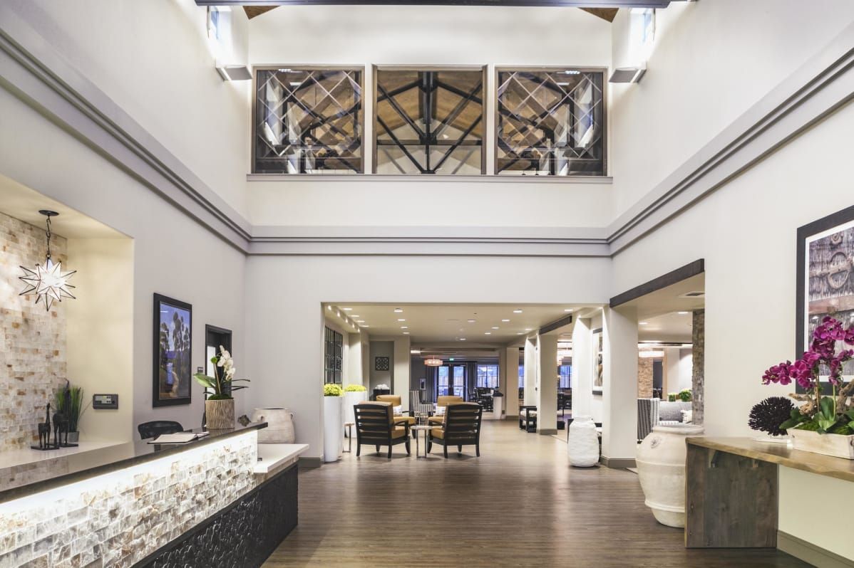 A spacious and well-designed hotel lobby with a reception desk and seating area.