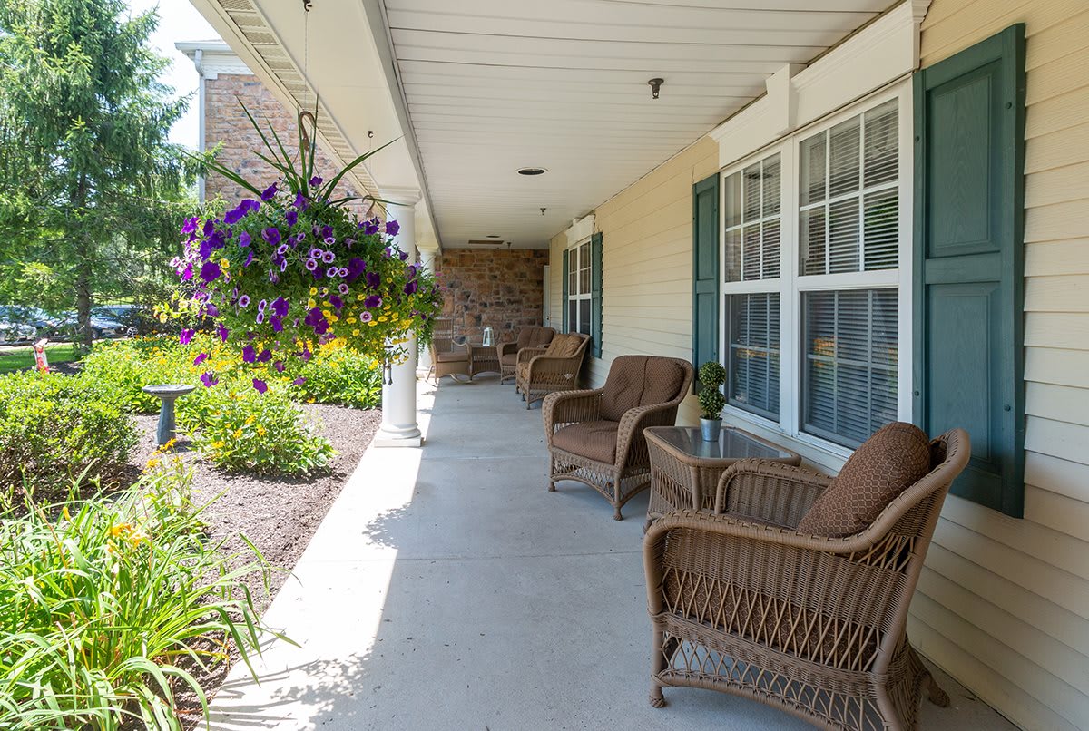 A sunny porch with wicker chairs and hanging plants.