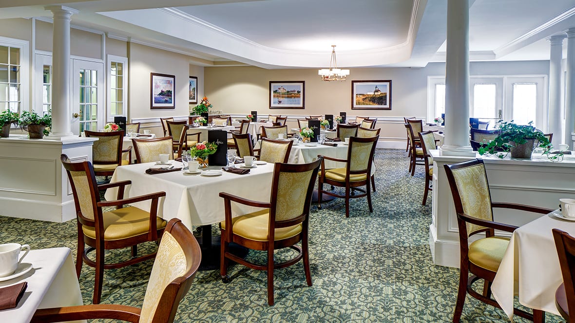 A well-arranged dining room with neatly set tables and comfortable chairs.
