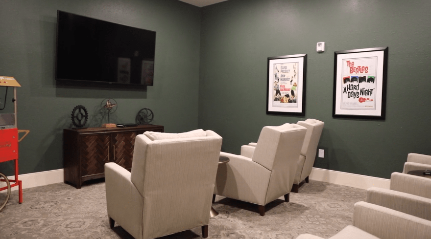 A cozy home theater setup with recliner chairs and a large TV.