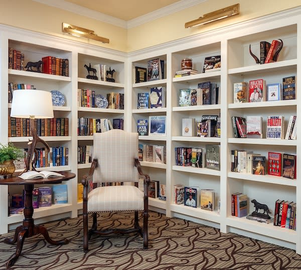 A cozy reading corner with a comfortable chair surrounded by well-stocked bookshelves.