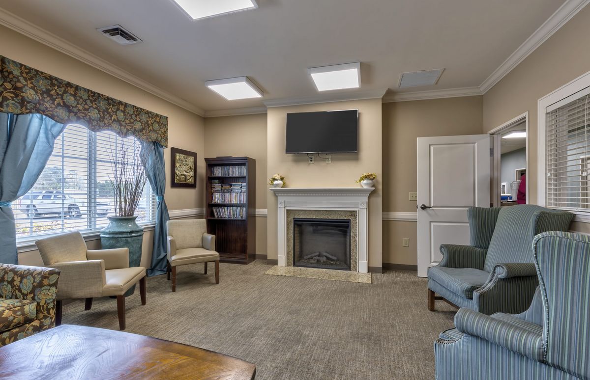 A cozy living room with a fireplace, TV, and comfortable seating.