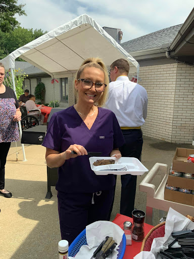 A healthcare staff member enjoying a meal at an outdoor event.