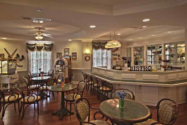 A cozy bistro interior with vintage decor and several tables and chairs.