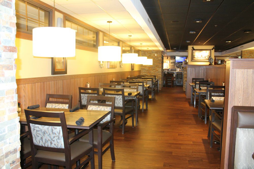 Interior view of a cozy restaurant dining area with neatly arranged tables and chairs.