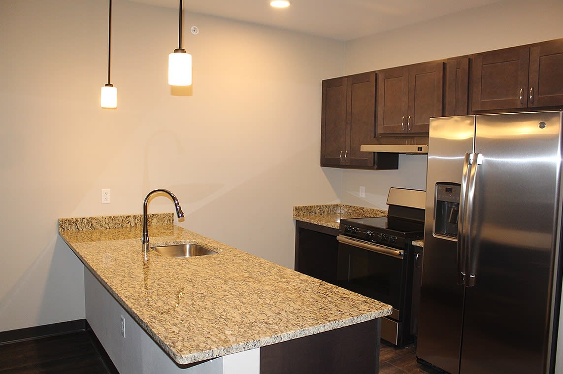 A modern kitchen with granite countertops and stainless steel appliances.