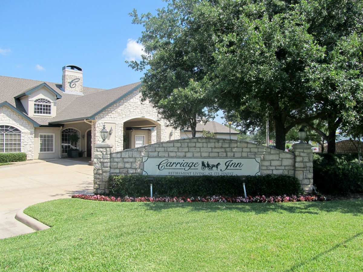 A residential building with a sign reading 'Cameron Park' surrounded by well-maintained landscaping and trees.