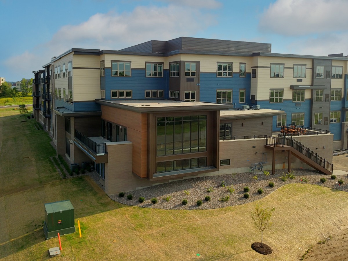 A modern school building with a landscaped exterior under a cloudy sky.