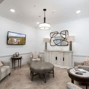 A modern living room featuring artistic wall decor, elegant lighting, and comfortable seating.