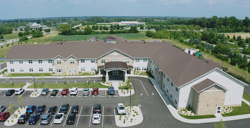 Aerial view of a modern residential building with a spacious parking lot.