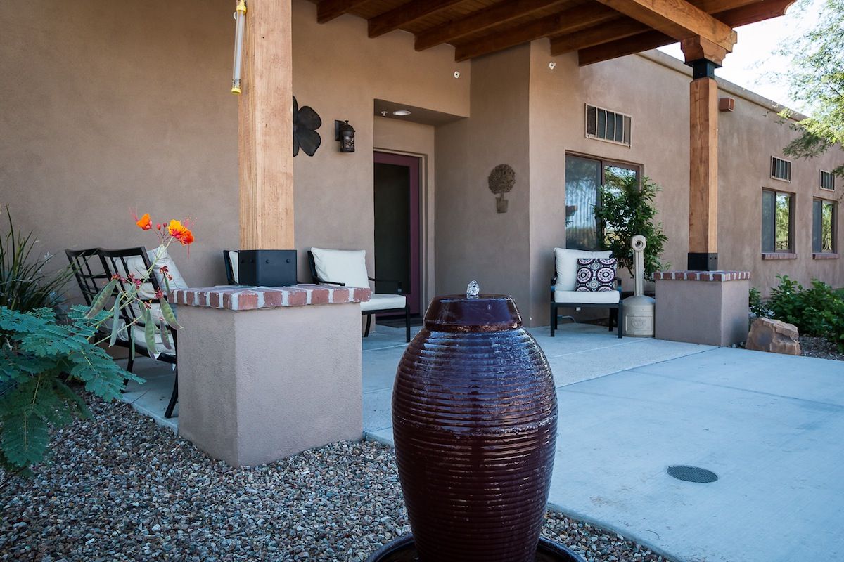 A cozy outdoor patio featuring a water fountain and comfortable seating.