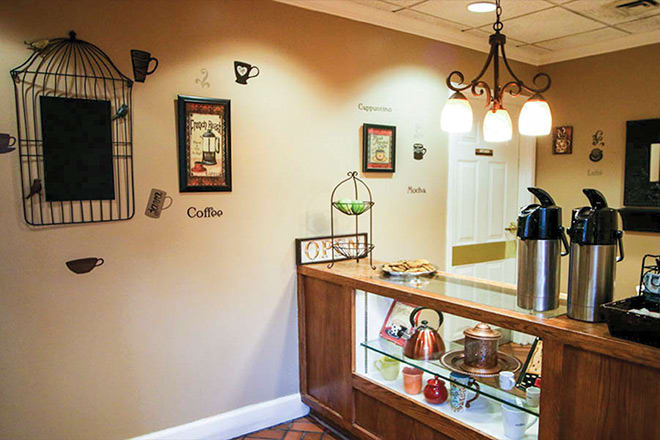 A cozy coffee station with warm lighting and decorative wall art.