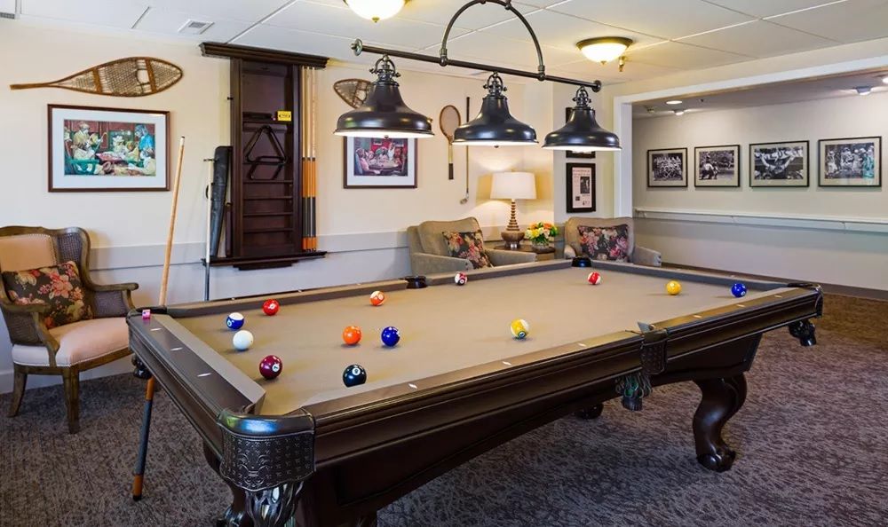 A cozy game room with a pool table and comfortable seating.