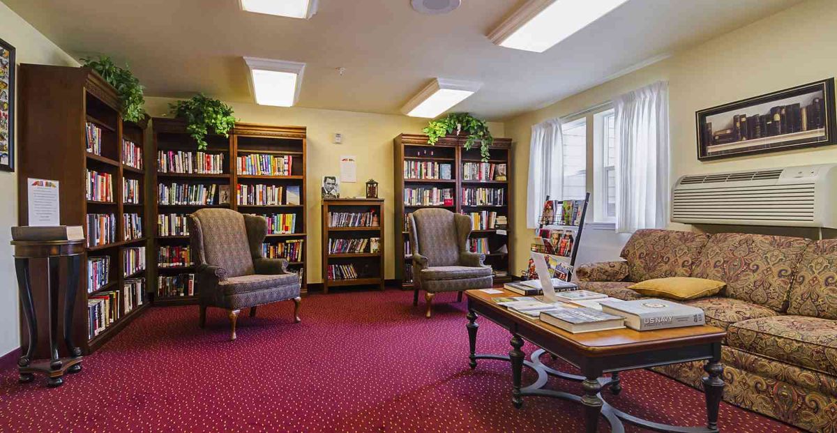 A cozy reading room with bookshelves and comfortable armchairs.