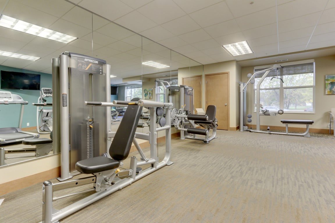 A clean and modern gym with various workout machines.