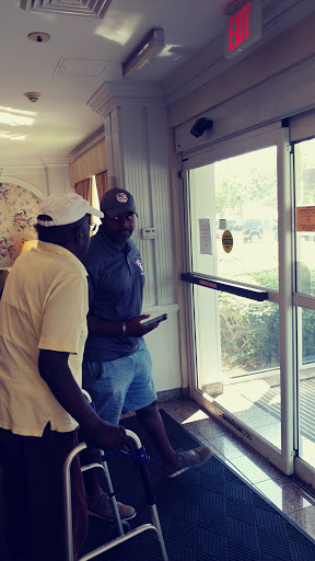 Two men having a discussion while standing inside a building near the entrance.