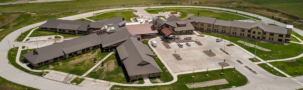 Aerial view of a rural building complex surrounded by greenery.