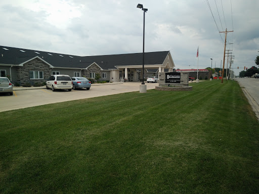 A view of a modern building surrounded by well-maintained grass and parking spaces.