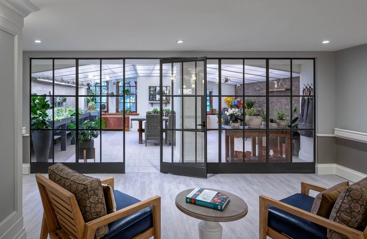 A modern living room with glass doors, comfortable seating, and stylish decor.