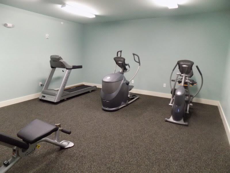 A small gym room with exercise equipment including treadmills and elliptical machines.