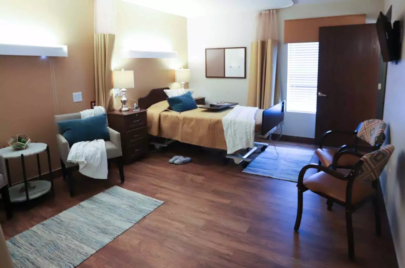 A cozy bedroom featuring a single bed, wooden flooring, and warm lighting with decorative elements.