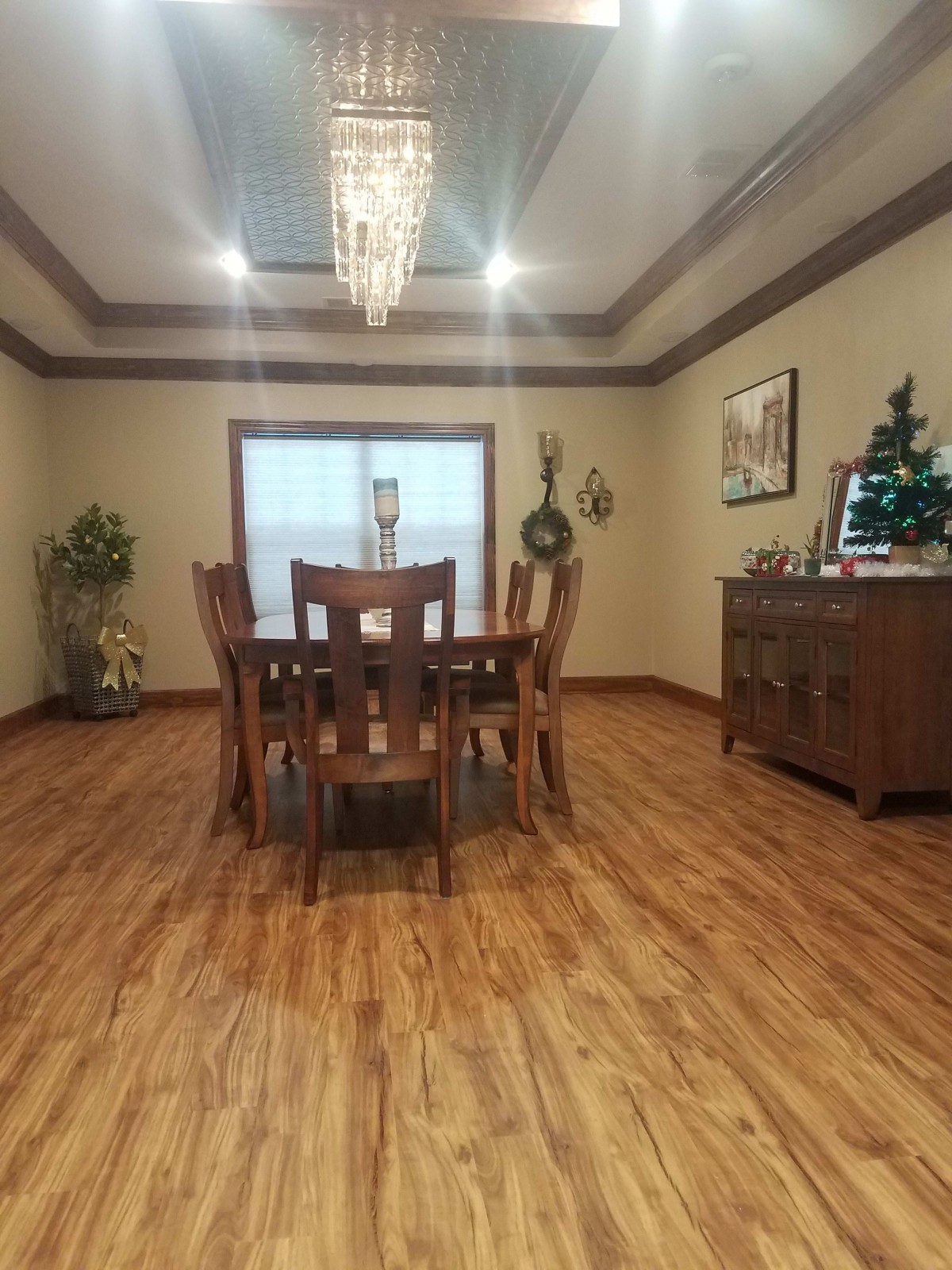 A well-decorated dining room with a wooden table and chandelier.