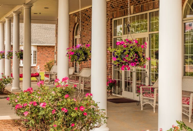 A charming porch with colorful hanging flower baskets and comfortable seating.