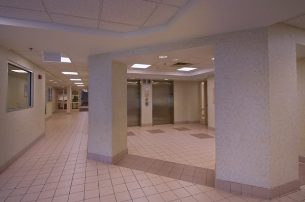 An empty lobby area with elevators and tiled flooring.