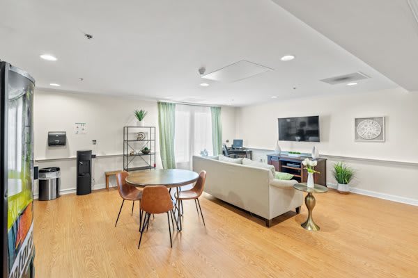 A modern living room with a sofa, television, and dining table.