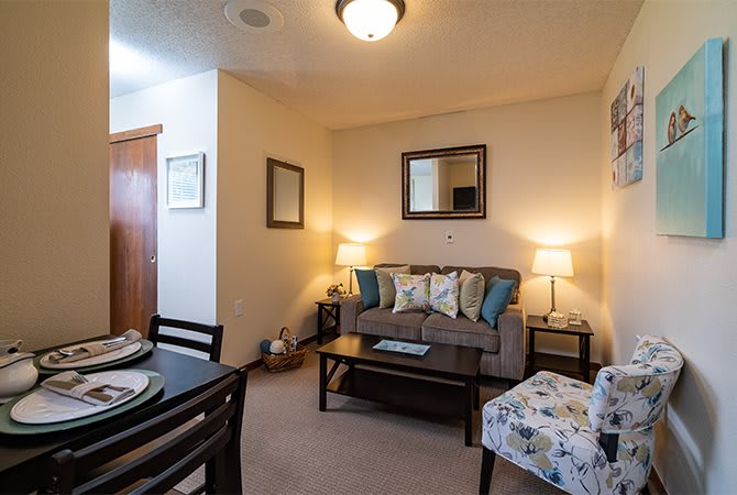 A cozy living room with a couch, coffee table, lamps, and decorative elements.