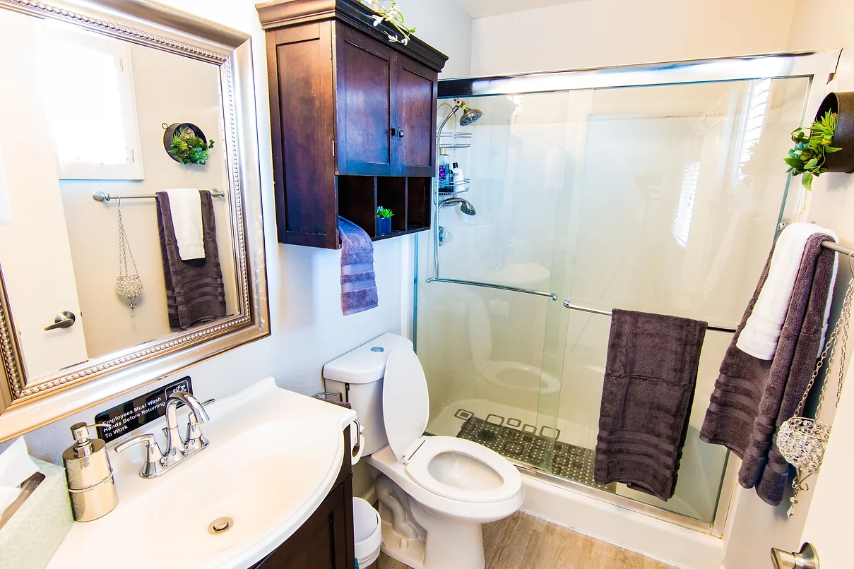 A modern bathroom with a sink, toilet, and glass-enclosed shower.