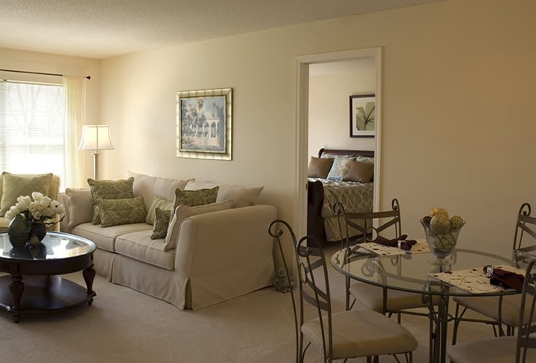 A cozy living room with a comfortable sofa, artwork on the walls, and an adjacent dining area.