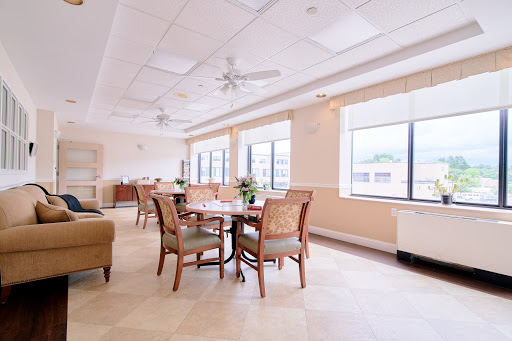 A bright and inviting dining area featuring comfortable furniture and large windows.