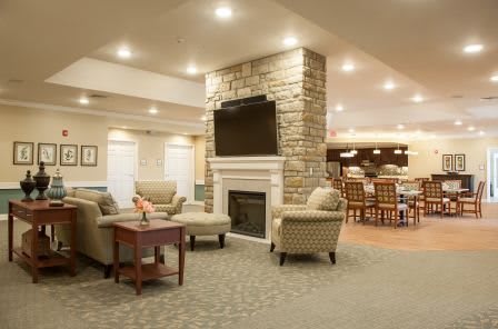 A cozy living room featuring a stone fireplace and seating area with comfortable furniture.