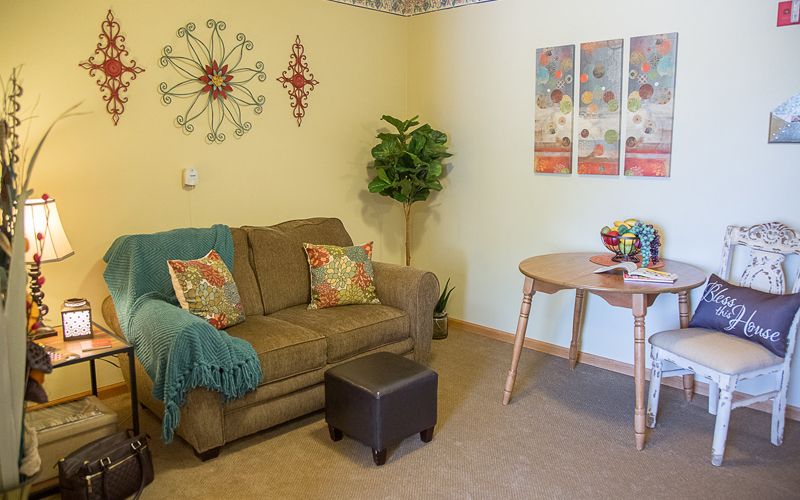Cozy living room with a sofa, wall decor, and a small table.