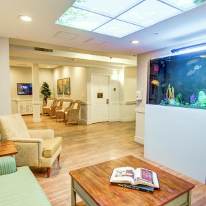A modern waiting room featuring an aquarium and comfortable seating.