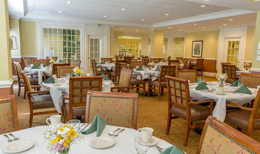 An elegantly set dining room with neatly arranged tables and chairs.