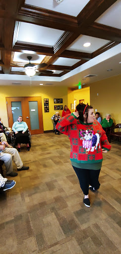 A festive holiday performance at a senior community center, featuring a participant in a colorful sweater.