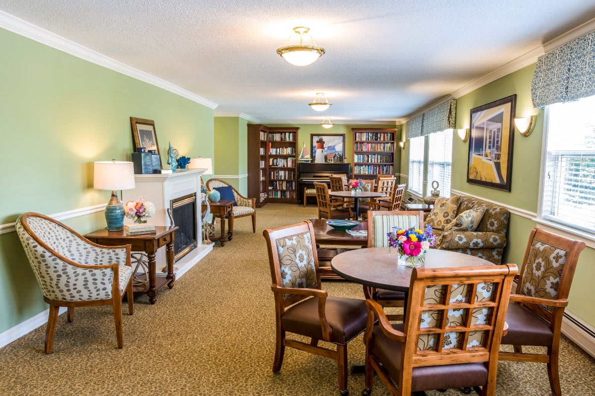 A cozy living room with bookshelves, a fireplace, and comfortable seating arrangements.