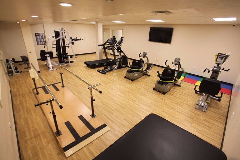 A well-equipped gym with treadmills, ellipticals, and other exercise machines.