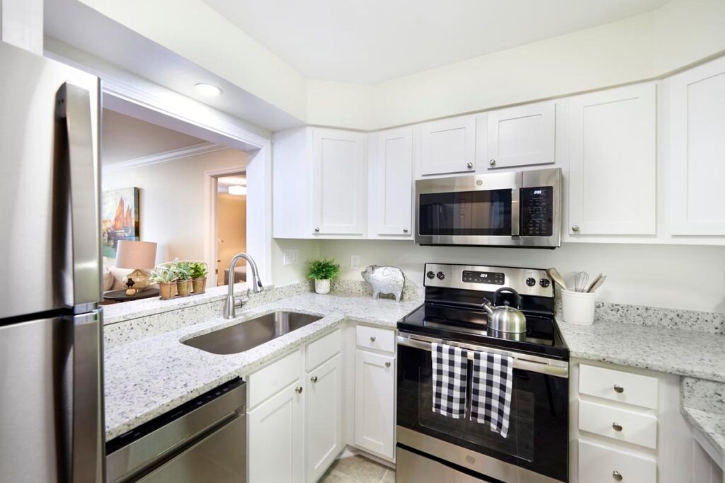 A modern kitchen with white cabinets and stainless steel appliances.