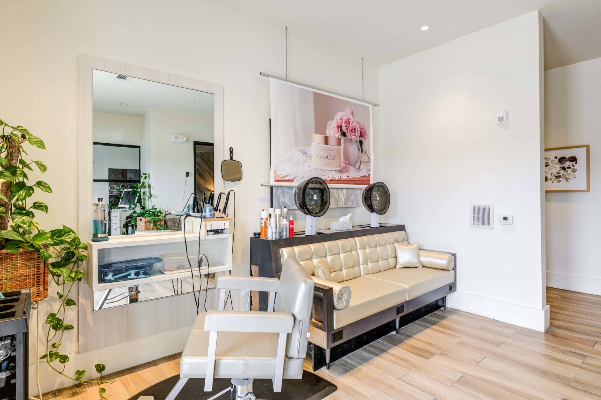 A modern living room with a stylish sofa and chair, featuring wood flooring and decorative elements.