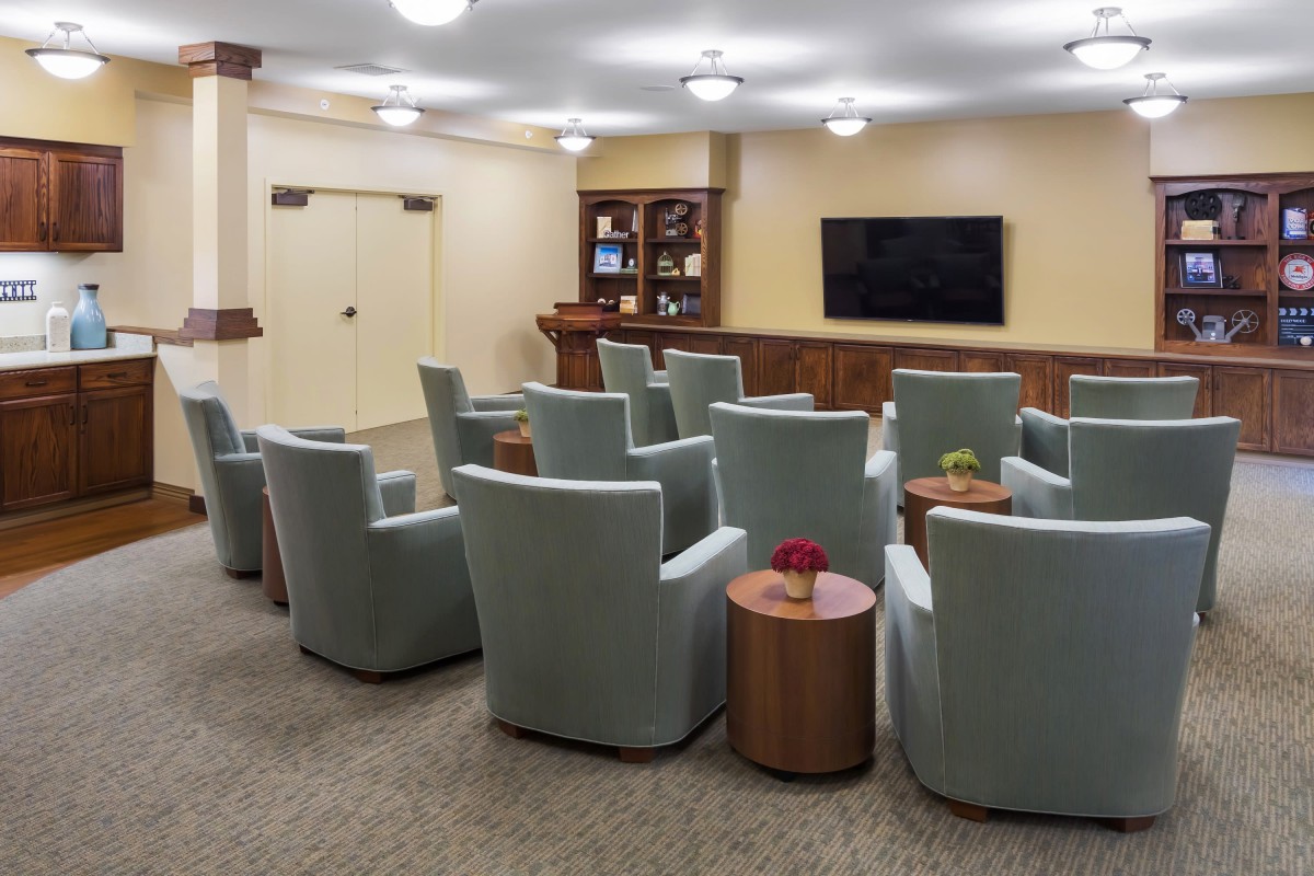 A well-arranged conference room featuring comfortable seating and a large television screen for presentations.