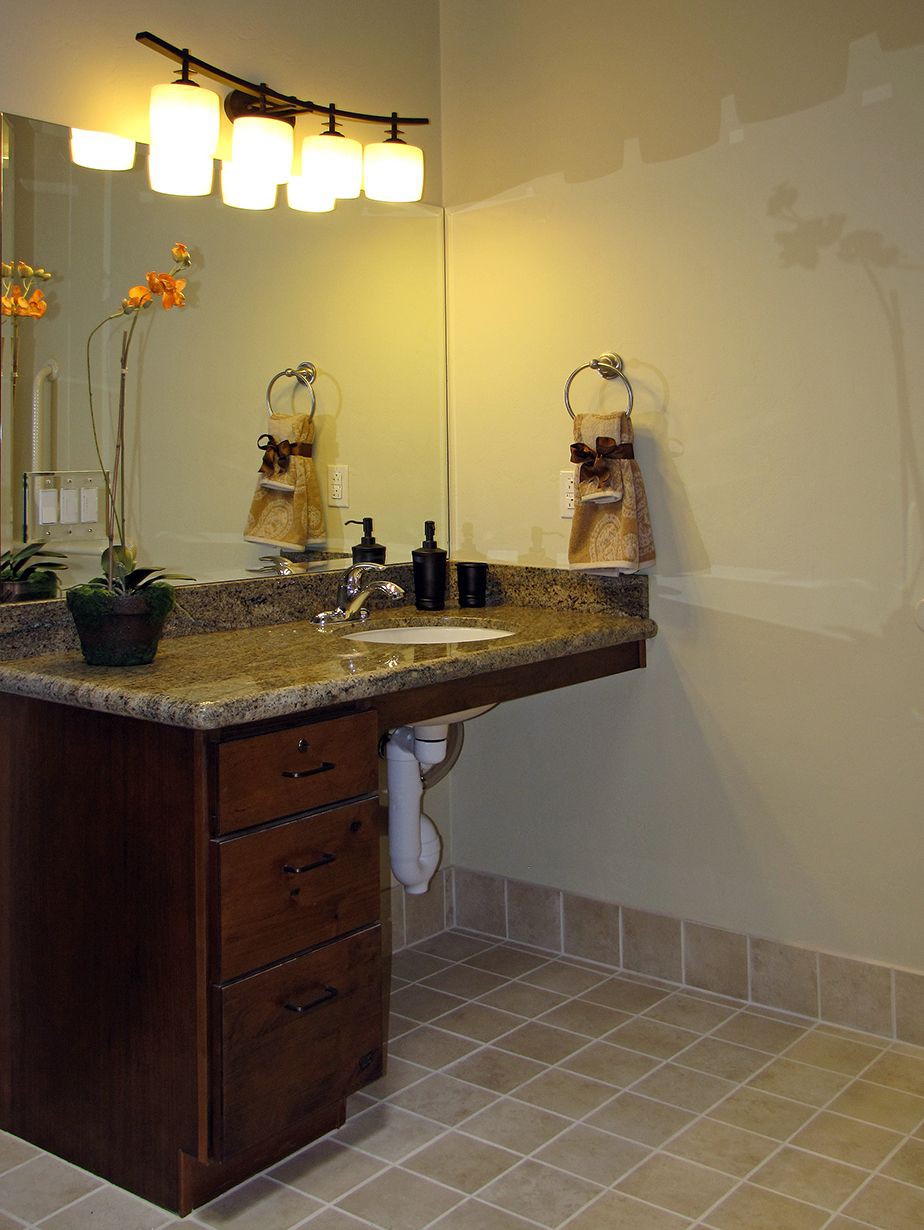 Modern bathroom with vanity, mirror, and elegant lighting.
