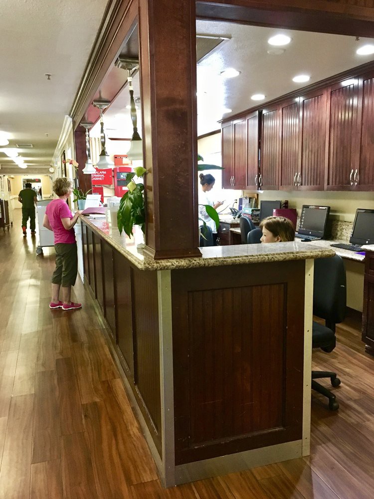 Reception area with people interacting and working at desks.