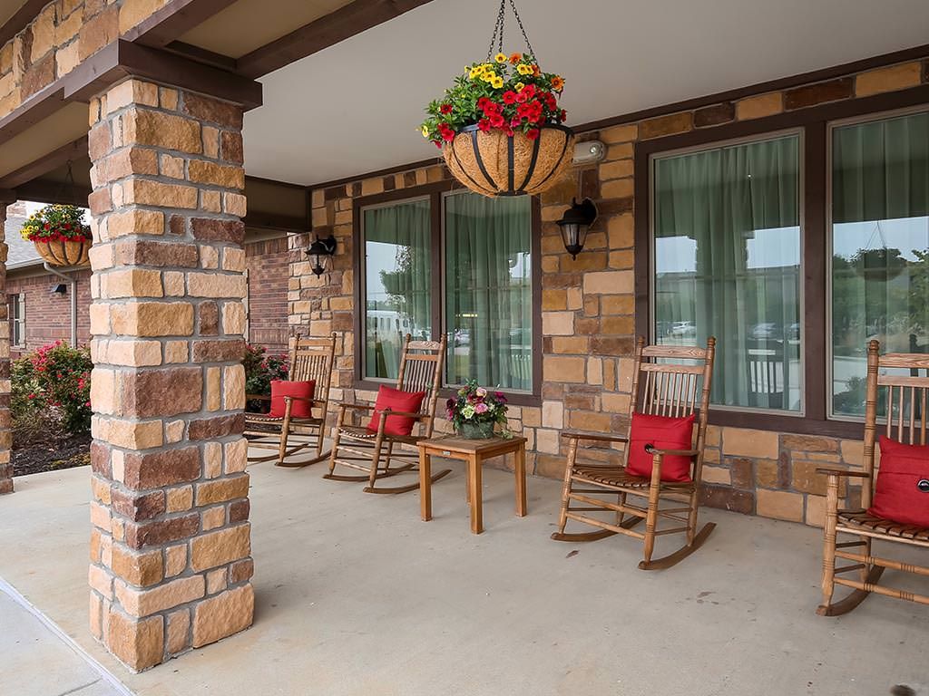 A cozy porch with rocking chairs and a hanging plant.