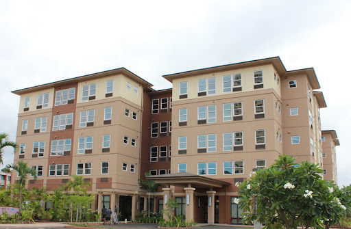 A modern multi-story residential building featuring large windows and a welcoming entrance.