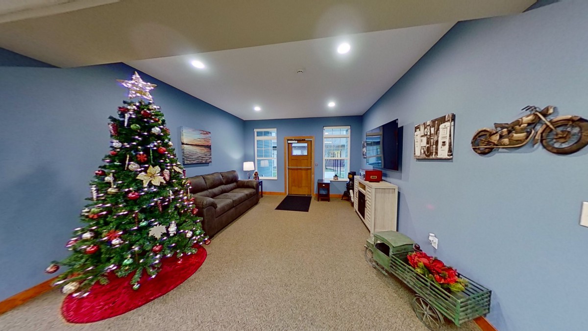 A cozy living room decorated for the holidays with a Christmas tree and comfortable seating.