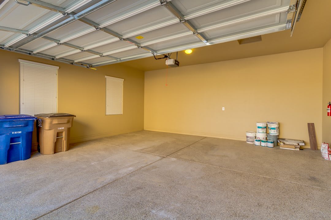 A clean, empty garage with a concrete floor and an overhead door.