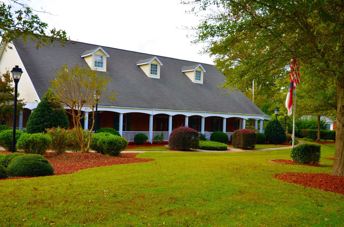 A charming house with a well-maintained lawn and garden.